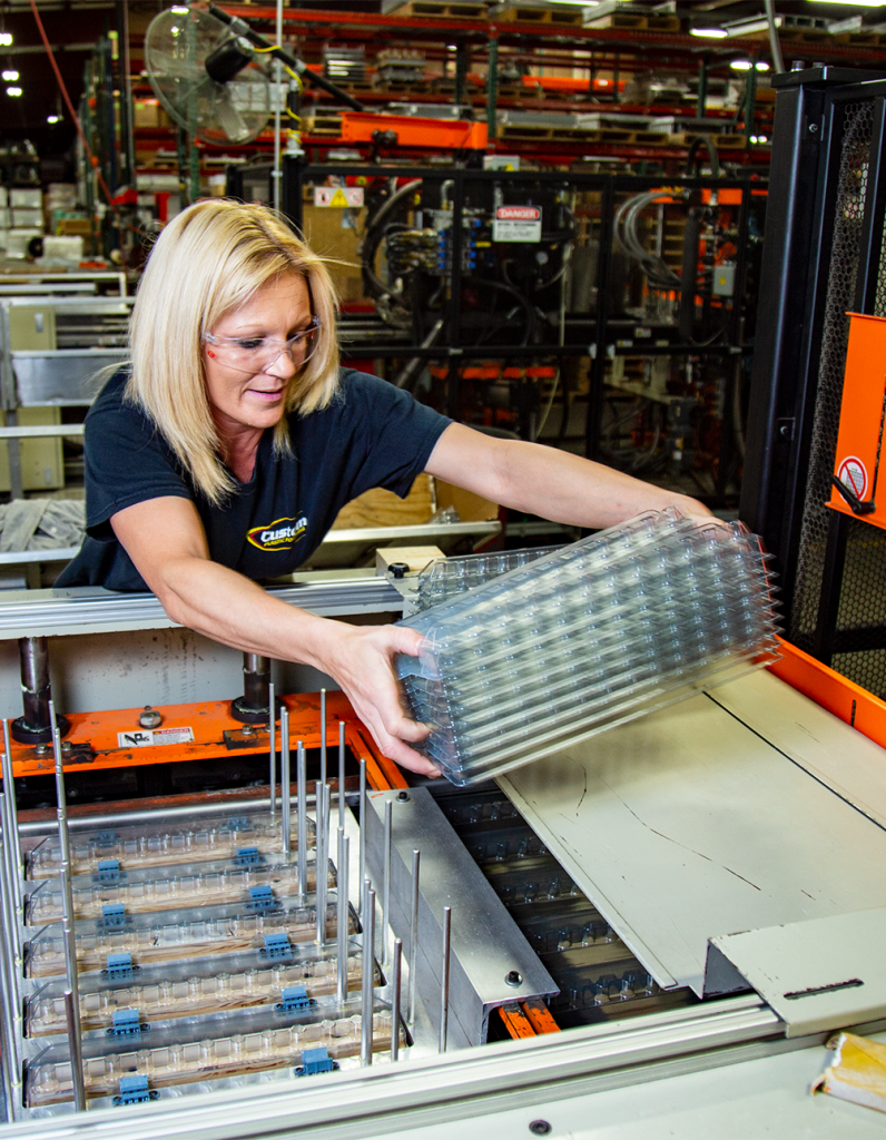 thin gauge thermoforming employee working Custom Plastic Forming